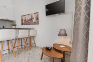 a living room with a table and chairs and a television at The Little Loft in Pefkochori