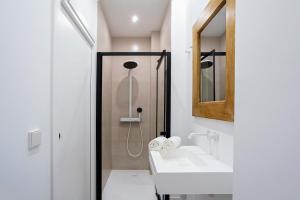 Un baño blanco con lavabo y ducha. en Genteel Home Castilla IV, en Sevilla