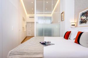 Un dormitorio con una cama blanca con un libro. en Genteel Home Castilla IV, en Sevilla 6 fotos más