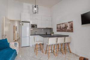 a kitchen and living room with a table and chairs at The Little Loft in Pefkochori