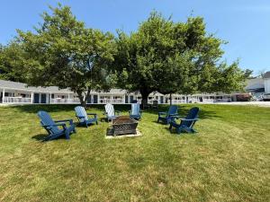 a group of chairs and a table in the grass at Yardarm Motel in Searsport