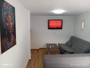 a living room with a couch and a painting on the wall at La posada del Mozarabe in Alquife