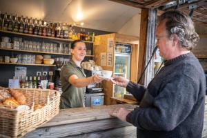 una mujer dándole una taza de café a un hombre en Huttopia Oleron Les Pins, en Saint-Trojan-les-Bains