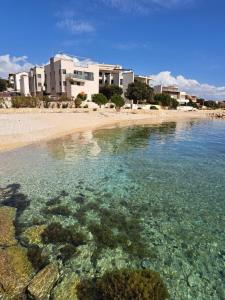 een waterlichaam met een strand en gebouwen bij Beach apartment in Mandre in Mandre