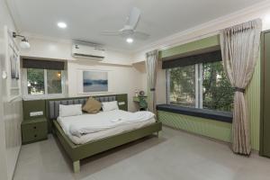 a bedroom with a bed and a window at Apple Tree Apartments Koregaon Park in Pune