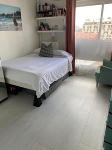 Un dormitorio con una cama y una ventana grande. en Parisian Peaceful Apartment with Stunning View in Montmartre area, en París
