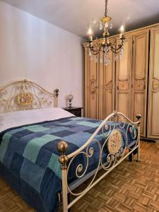 a bedroom with a bed and a chandelier at La Terrazza in Tarzo