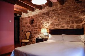 Un dormitorio con una cama, una mesa y una silla. en Hotel Rural Nobles de Navarra, en Áibar