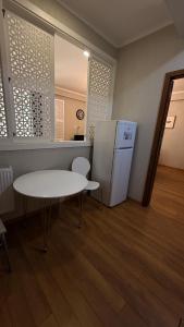 cocina con mesa blanca y nevera en Rustaveli Luxe Residence, en Tiflis