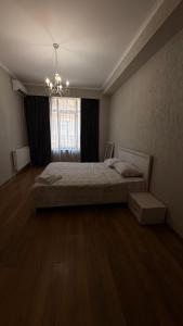 Un dormitorio con una cama y una ventana grande. en Rustaveli Luxe Residence, en Tiflis
