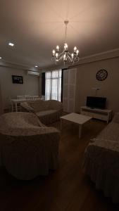 Una habitación con tres camas y una lámpara de araña. en Rustaveli Luxe Residence, en Tiflis