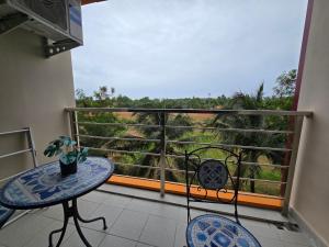 ein Balkon mit einem Tisch und Stühlen auf einem Balkon in der Unterkunft 777 Beach Condotel in Mai Khao Beach