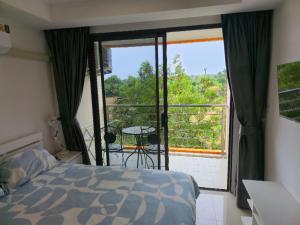 ein Schlafzimmer mit Bett und Blick auf einen Balkon in der Unterkunft 777 Beach Condotel in Mai Khao Beach + 28 Fotos