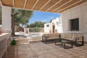 a patio with two benches and a flat screen tv at TD Trullo Diamante – Pure Relaxation Privacy in Putignano