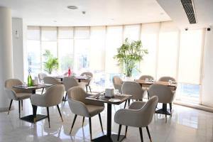 um restaurante com mesas e cadeiras e grandes janelas em The Theme, Jaipur em Jaipur mais 36 fotografias