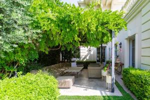a garden with a bench and a large tree at S2 House for 12p swimming pool AC BBQ 10mins from Sea in Nice