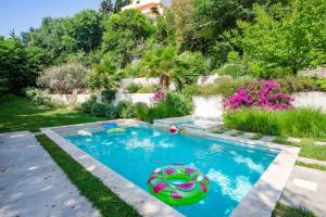 a swimming pool in a garden with an inflatablevisor in a yard at S2 House for 12p swimming pool AC BBQ 10mins from Sea in Nice +115 photos
