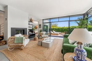 a living room with a green couch and a fireplace at Lavalliere - Villa de luxe avec piscine - 4 suites in Plouër-sur-Rance +26 photos