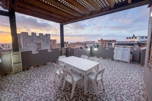 a table and chairs on a balcony with a view at Seaside Cozy Mini Villa Stay in Id Taleb