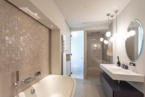 a bathroom with a tub and a sink and a mirror at S2 House for 12p swimming pool AC BBQ 10mins from Sea in Nice