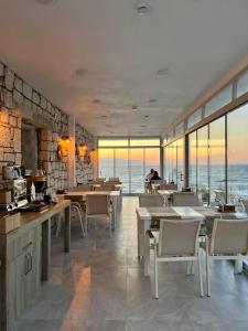 a restaurant with tables and chairs and a view of the ocean at Aporte Hotel Cesme in Çeşme