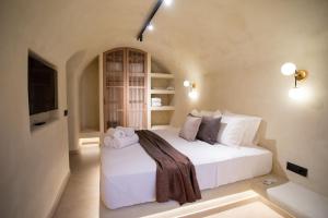 una camera da letto con un letto bianco in una stanza di Iama Luxury Suite Santorini a Imerovigli