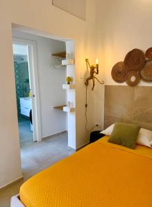 1 dormitorio con 1 cama con colcha de color naranja en Vittoria Apart, en Siracusa