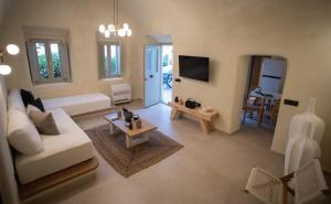 un soggiorno con un divano e un tavolo di Iama Luxury Suite Santorini a Imerovigli