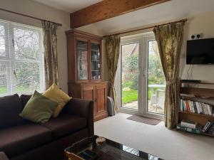a living room with a couch and a sliding glass door at Little Furrows, Wenhaston in Wenhaston