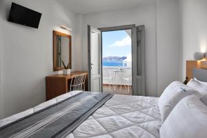 una camera da letto con un letto e vista sull'oceano di Santorini View ad Akrotírion