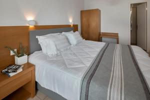 a bedroom with a large white bed and a wooden desk at Santorini View in Akrotiri