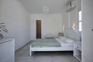 a white bedroom with a bed and a window at Santorini View in Akrotiri