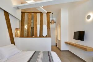 a bedroom with a bed and a flat screen tv at Santorini View in Akrotiri