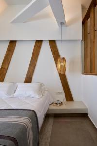 a bedroom with a bed and a table with a lamp at Santorini View in Akrotiri