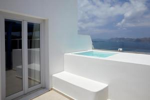 a white house with a swimming pool on a balcony at Santorini View in Akrotiri