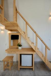 a wooden staircase with a table and bench underneath it at Santorini View in Akrotiri
