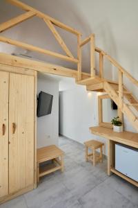 a living room with a wooden staircase and a tv at Santorini View in Akrotiri