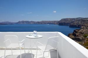 a white table and chairs with a view of the water at Santorini View in Akrotiri