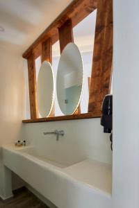 a bathroom with two mirrors above a sink at Santorini View in Akrotiri