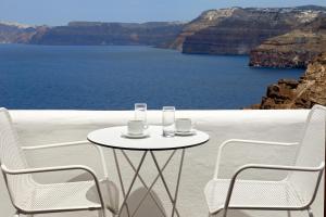 a table and chairs with a view of the ocean at Santorini View in Akrotiri