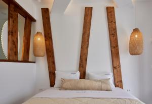 a bedroom with a bed with two lights on the wall at Santorini View in Akrotiri