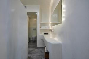 a white bathroom with a sink and a toilet at Santorini View in Akrotiri