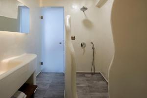 a white bathroom with a sink and a shower at Santorini View in Akrotiri