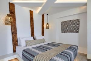a bedroom with a bed with white walls at Santorini View in Akrotiri