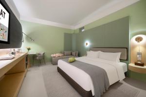 a bedroom with a large white bed and a couch at Layflat Hotel in Shenzhen