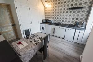 a small kitchen with a table and a sink at LE MANOIR PARADI in Presles-et-Thierny +25 photos