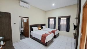 Postel nebo postele na pokoji v ubytování Yuwono Hotel & Villa Malioboro