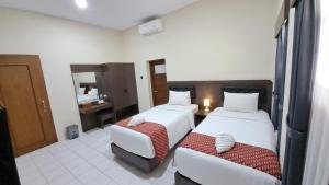 Postel nebo postele na pokoji v ubytování Yuwono Hotel & Villa Malioboro