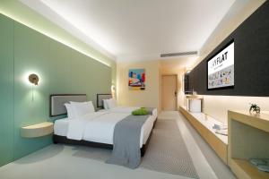 a bedroom with a large white bed and a tv at Layflat Hotel in Shenzhen