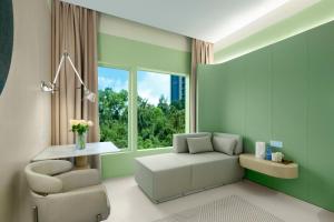 a living room with a chair and a table and a window at Layflat Hotel in Shenzhen